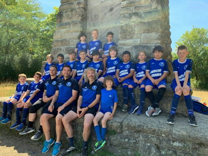 Gruppenfoto der Fußball-Junioren mit Trainern.